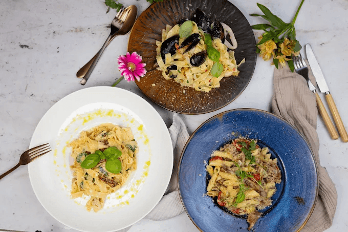 Trzy talerze makaronów — tagliatelle i penne w różnych sosach