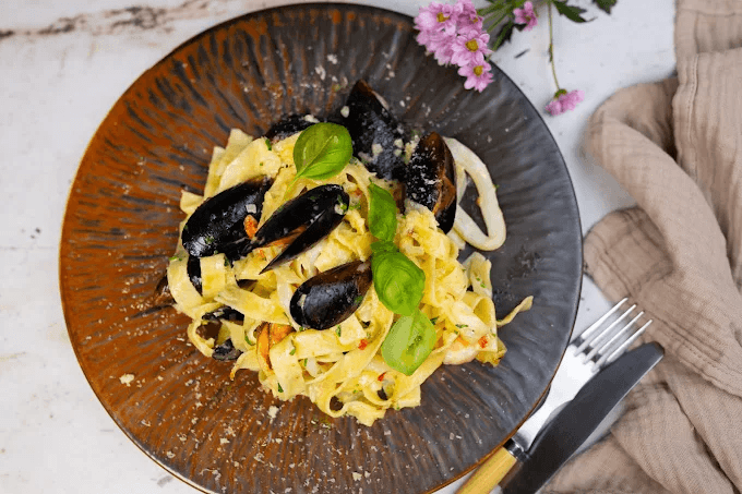 Tagliatelle z owocami morza — małże i kalmary w sosie winno-maślanym z bazylią