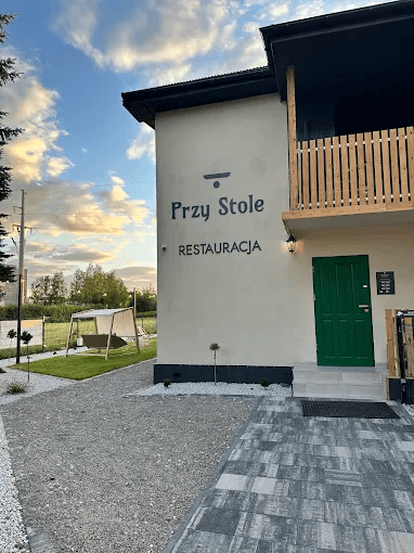 Budynek restauracji Przy Stole o zachodzie słońca, huśtawka ogrodowa w tle